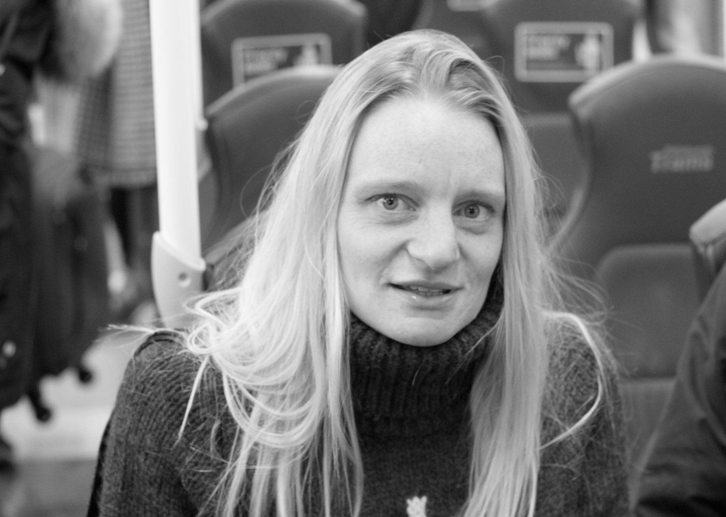 Paula Neail sitting in a cafe. Longstanding member of the Creative Agency team